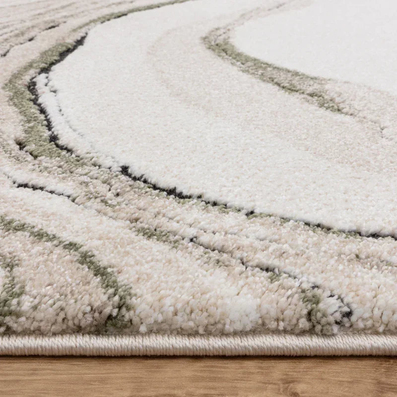 Cream and beige rug with abstract swirl pattern on wooden floor, close up view