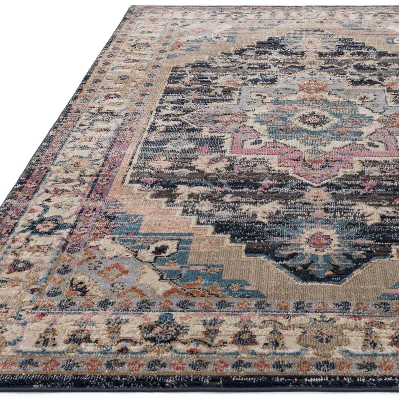 Multicoloured patterned area rug with geometric and floral motifs, low angle corner view