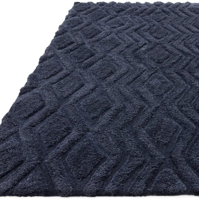 Textured navy rug with geometric raised diamond pattern, close-up angle highlighting details