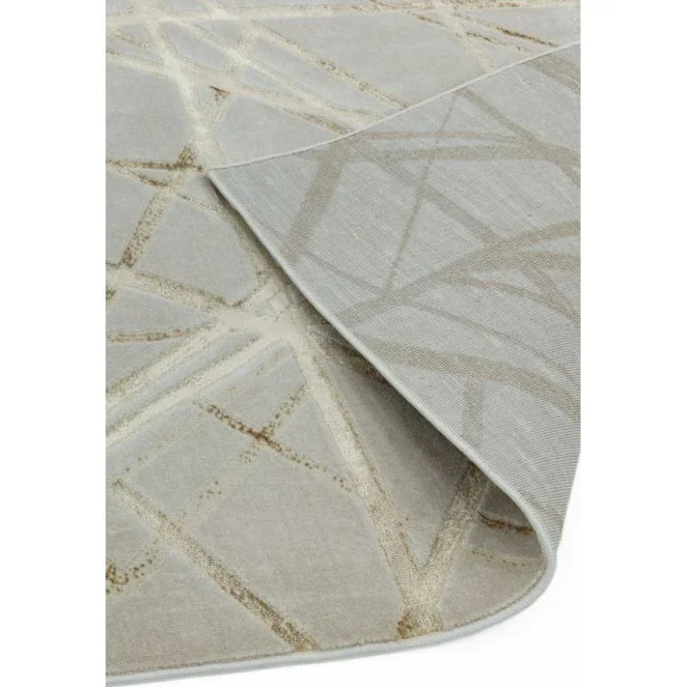Beige abstract pattern area rug corner fold shows texture and backing detail