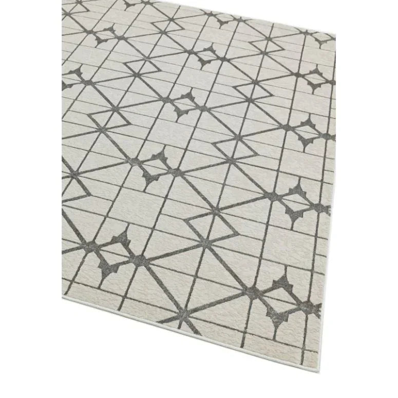 Beige area rug with geometric grey line pattern and star shapes, corner angle view