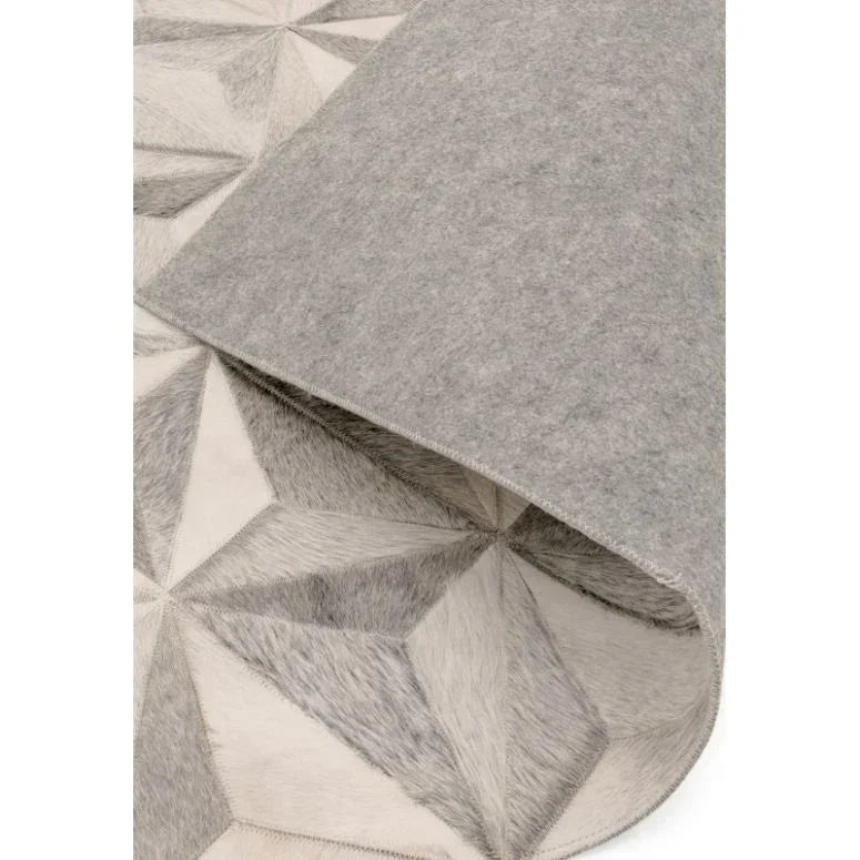 Grey geometric pattern rug with folded corner showing felt backing