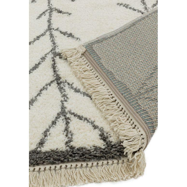 Beige patterned rug with fringe detail and grey geometric design, close-up corner view
