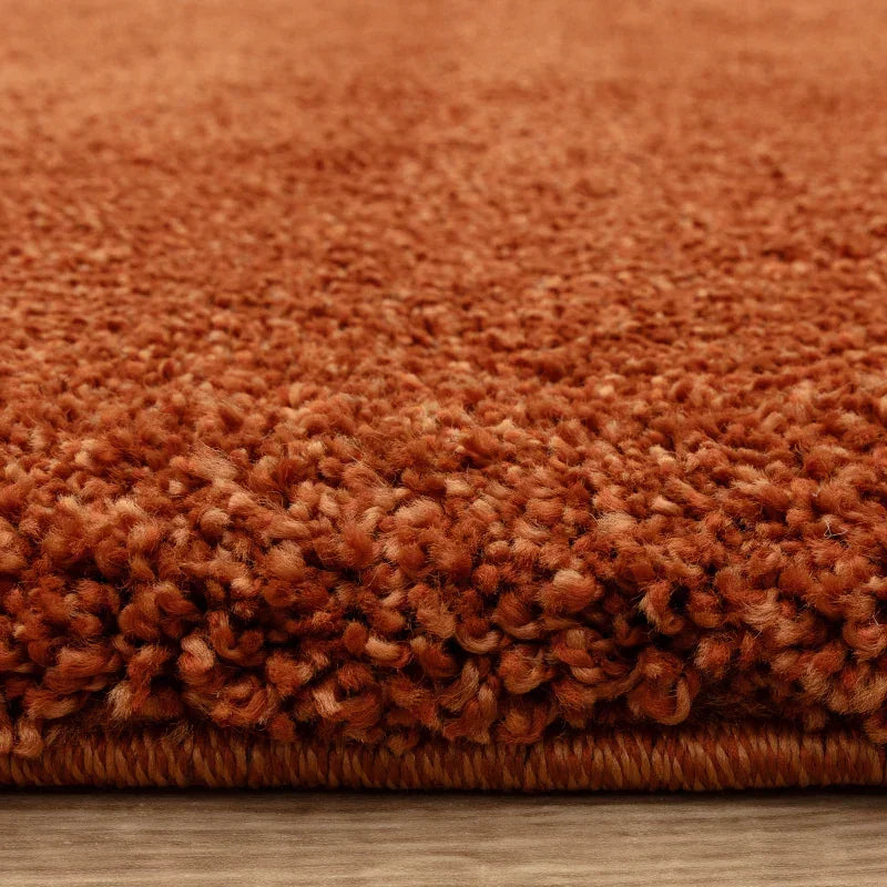 Closeup of thick pile orange shaggy rug on wooden floor