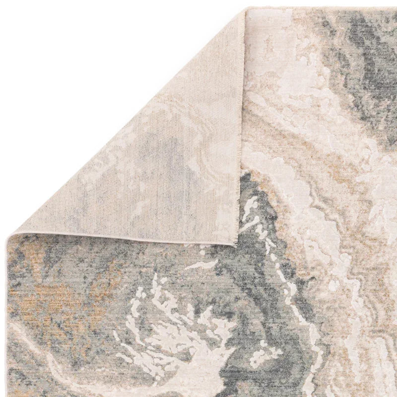 Marble pattern area rug with beige, grey and cream tones, corner folded to show texture