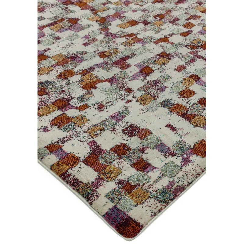 Abstract patterned area rug with multicolored squares on a cream background, corner view