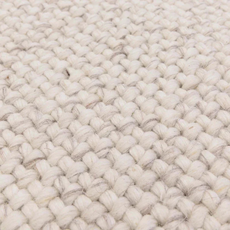 Closeup of cream wool rug weave texture