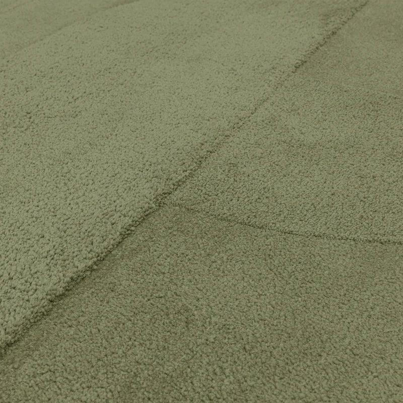 Close-up of sage green textured rug with soft pile and geometric stitching