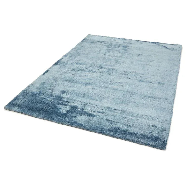 Light blue area rug with soft pile and subtle texture, shown from corner angle