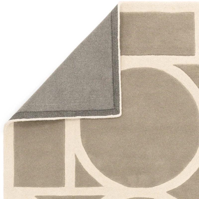 Beige and taupe geometric area rug with one corner folded to show backing detail