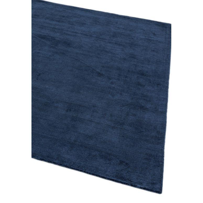 navy blue area rug with soft textured surface and clean edge corner detail