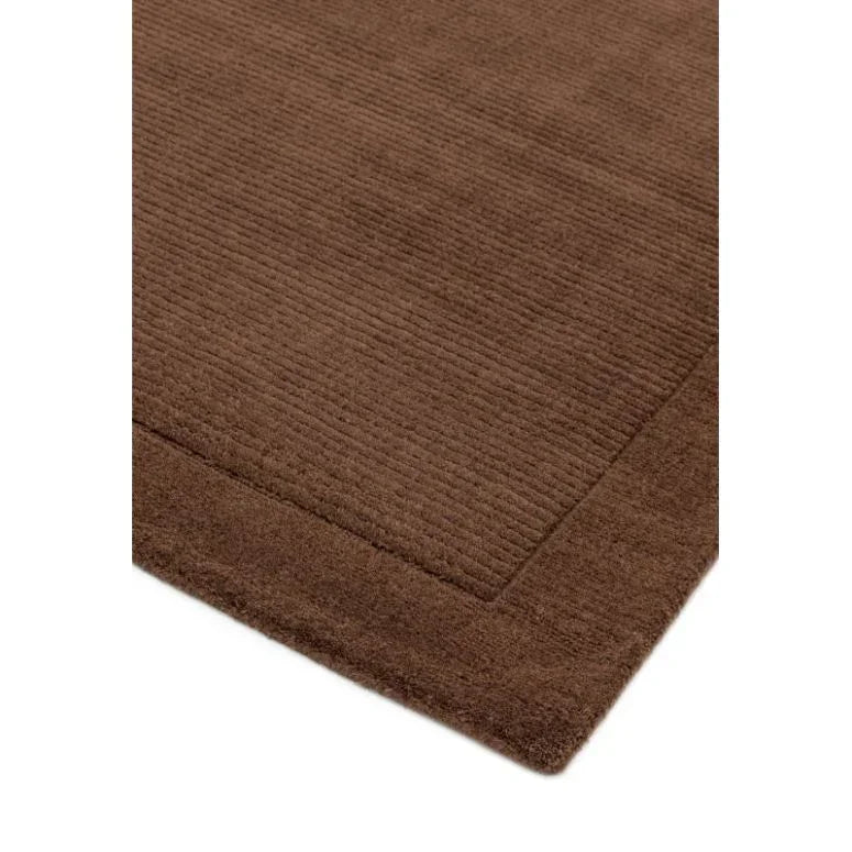 Brown textured rug with ribbed pattern and thick border corner view