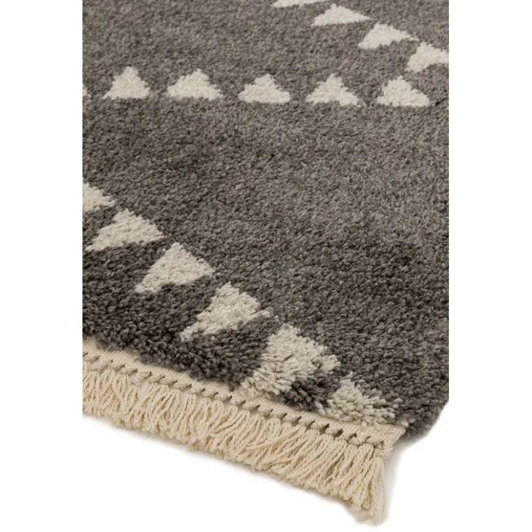 grey patterned rug with white geometric shapes and fringed edge detail