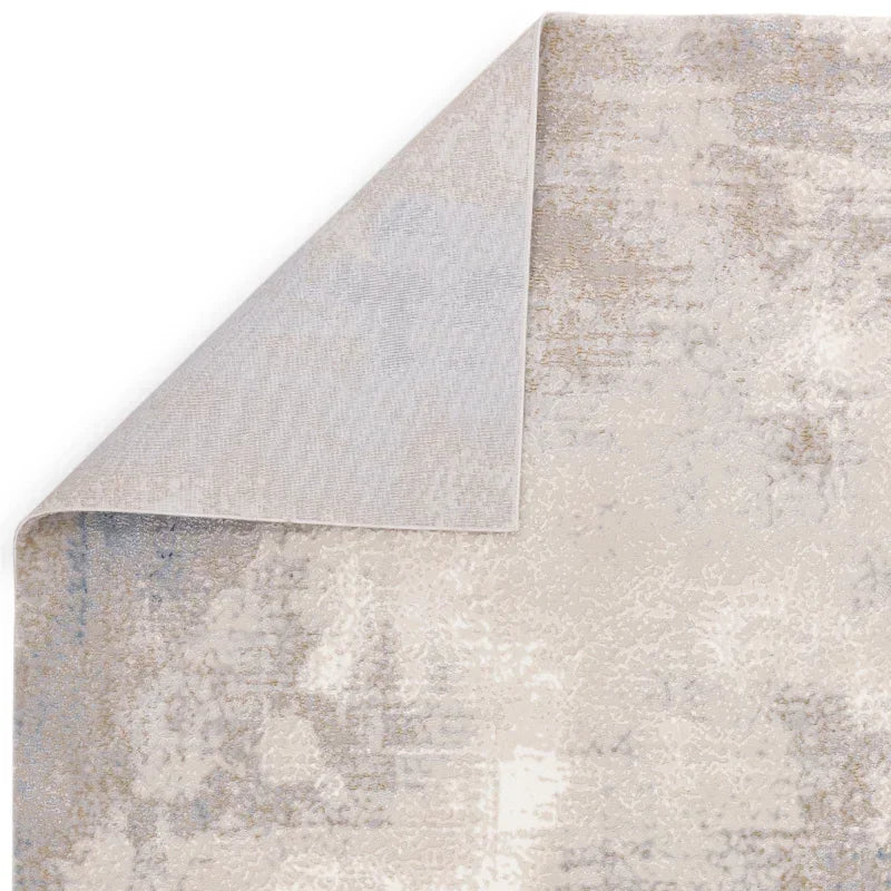 Neutral abstract area rug with textured pattern and corner lifted to show backing