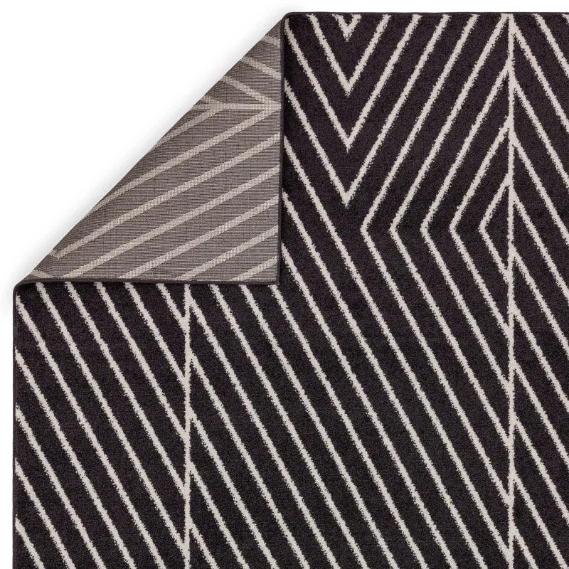 Black chevron striped rug with contrasting underside corner detail visible