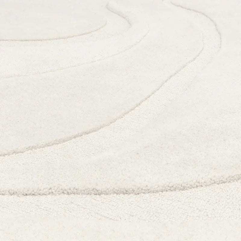Cream textured area rug with raised wave pattern close-up