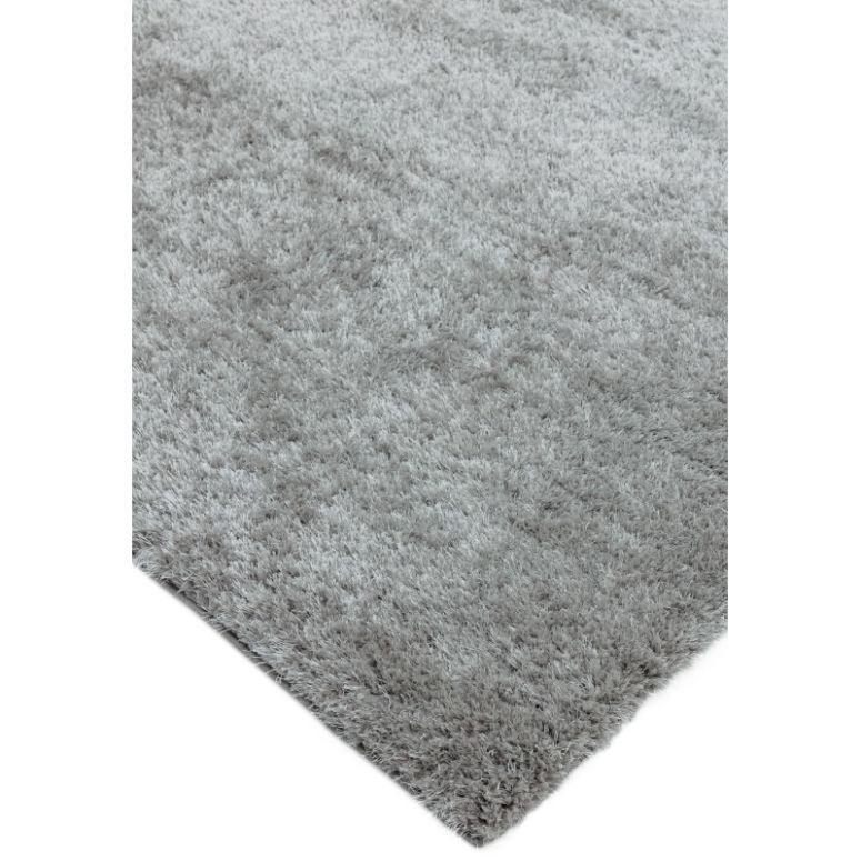 Light grey shaggy rug with soft pile, closeup of corner and texture