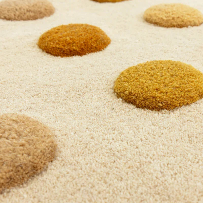 cream area rug with raised yellow and beige textured polka dots close up