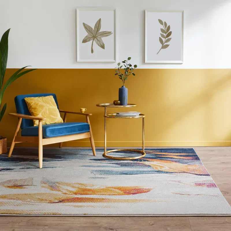 Modern yellow and blue rug in living room with blue armchair and gold accent table