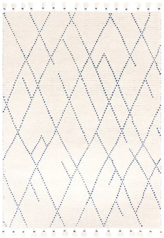Cream area rug with blue geometric diamond pattern and tassel edging