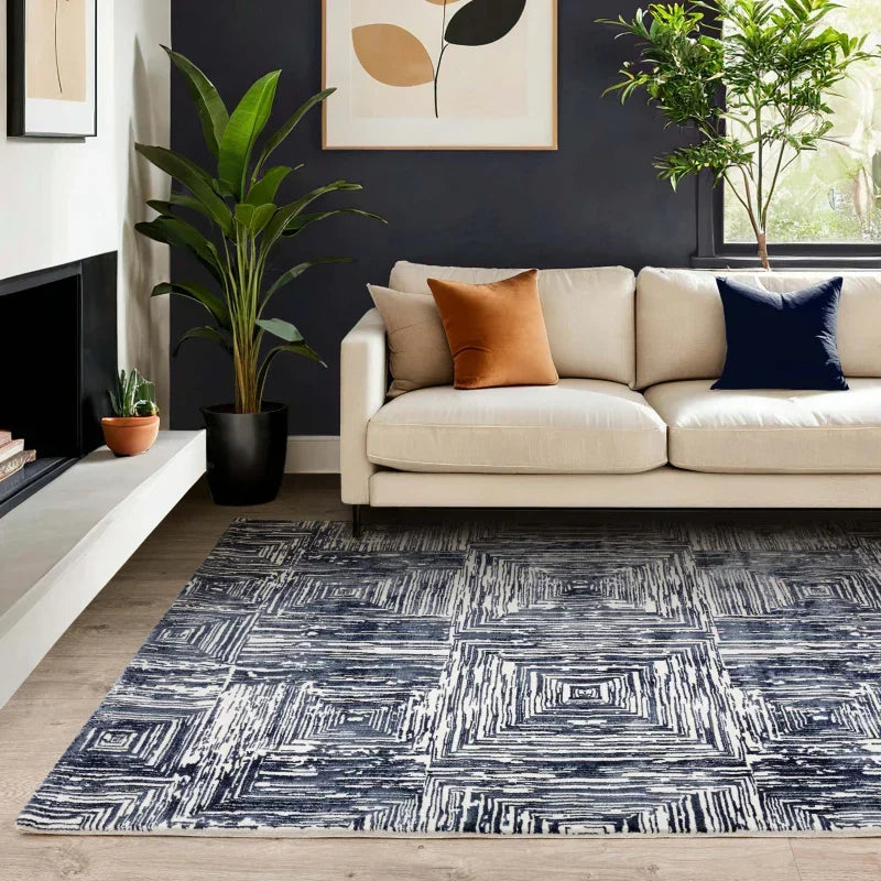 Modern living room with beige sofa, geometric patterned rug, and indoor plants