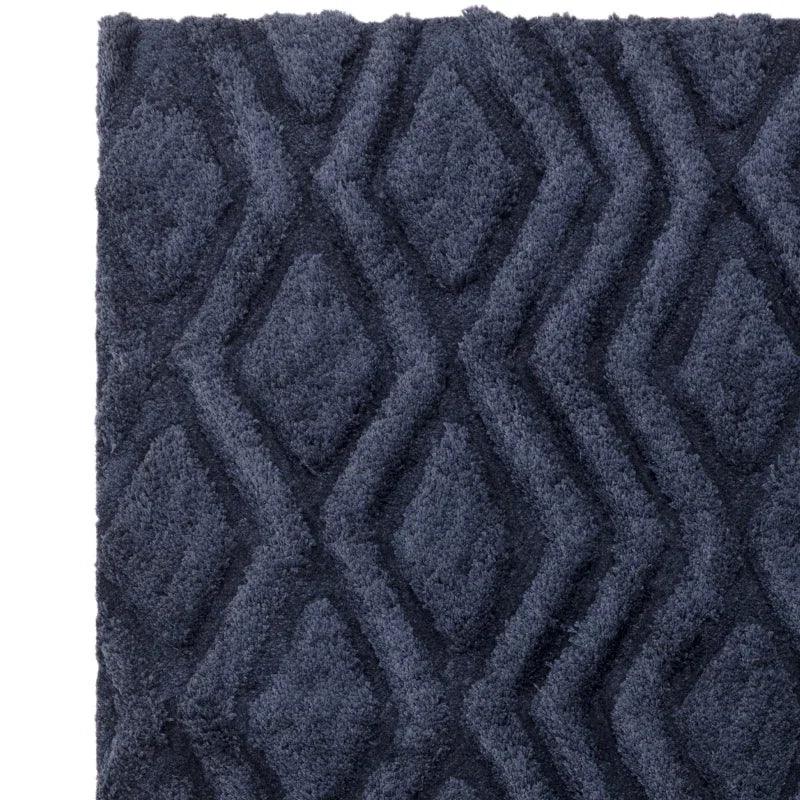 Navy geometric rug with textured diamond pattern and soft pile, close-up corner view