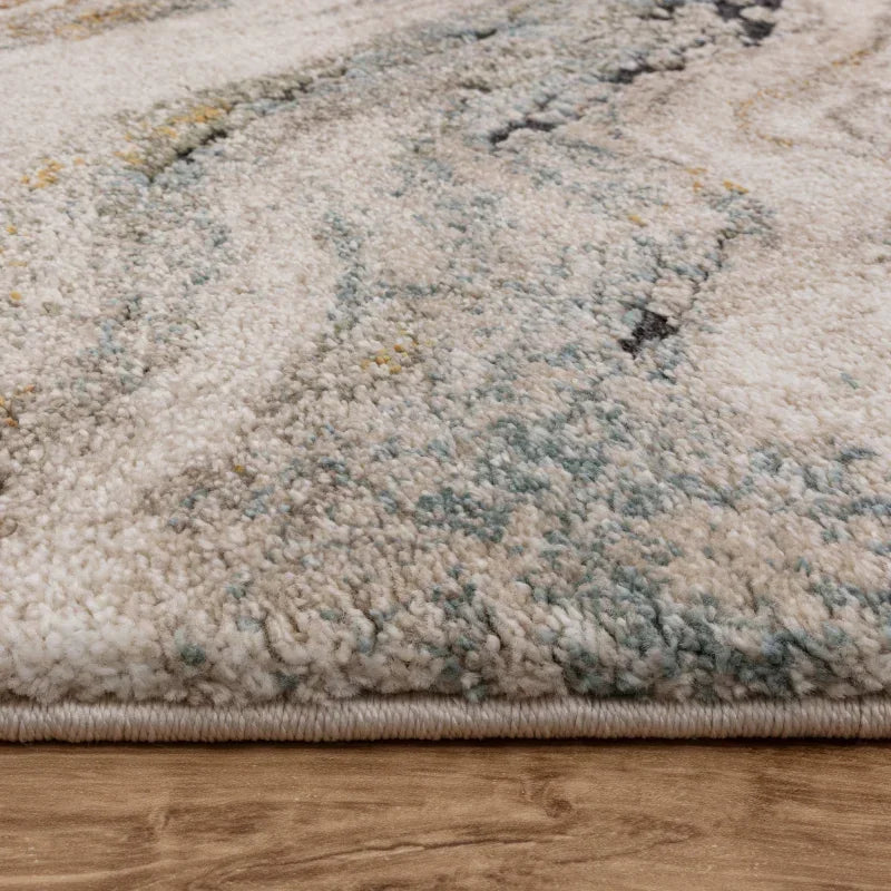Close-up of thick cream and blue patterned rug on wooden floor