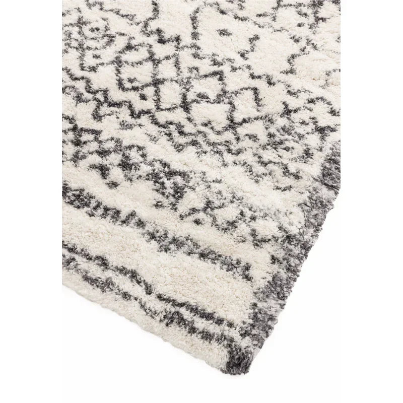 Cream and grey patterned rug corner close-up, thick pile and geometric design
