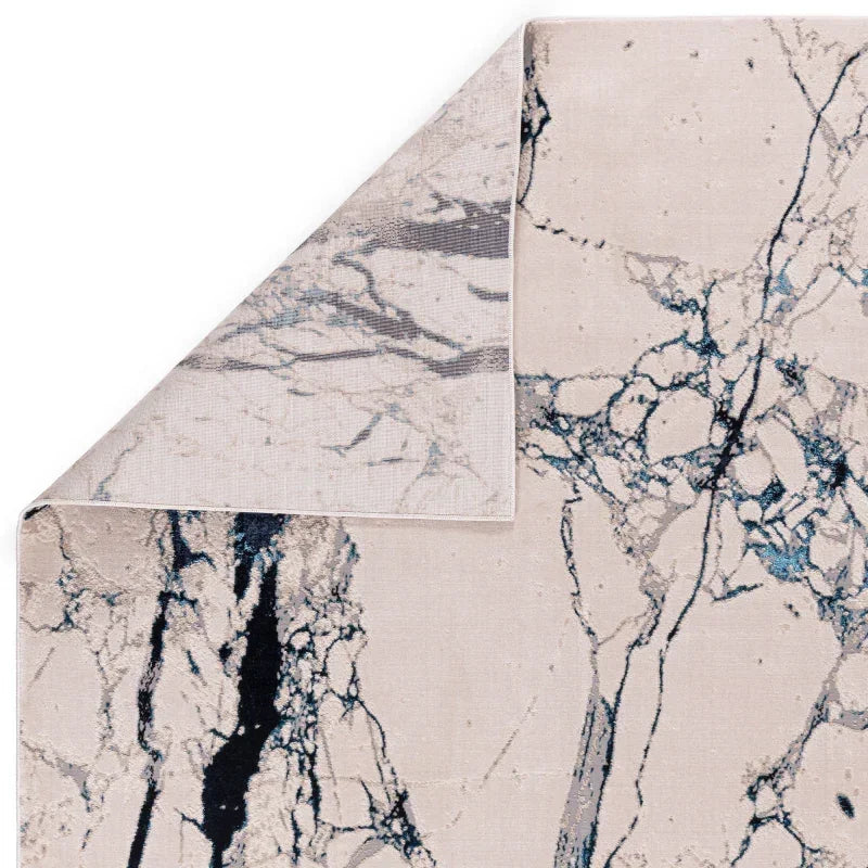 Marble effect area rug with blue and black veining and turned corner detail visible