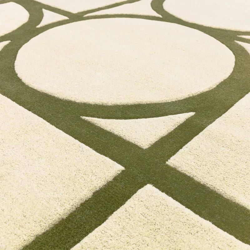 Cream and green modern rug with geometric circle and line pattern, closeup of pile texture