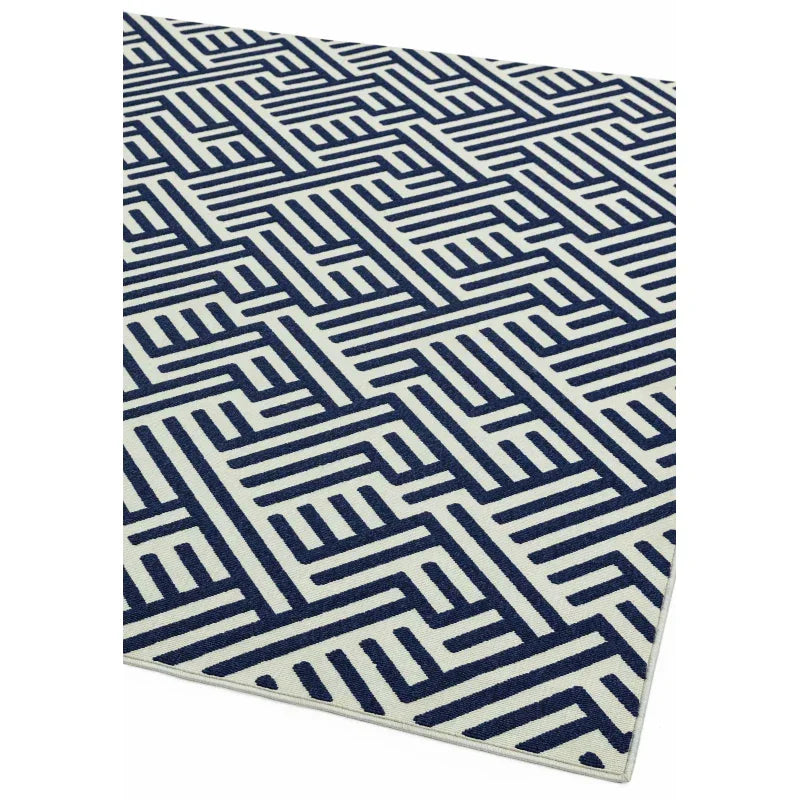 navy geometric patterned indoor rug with white background, corner view