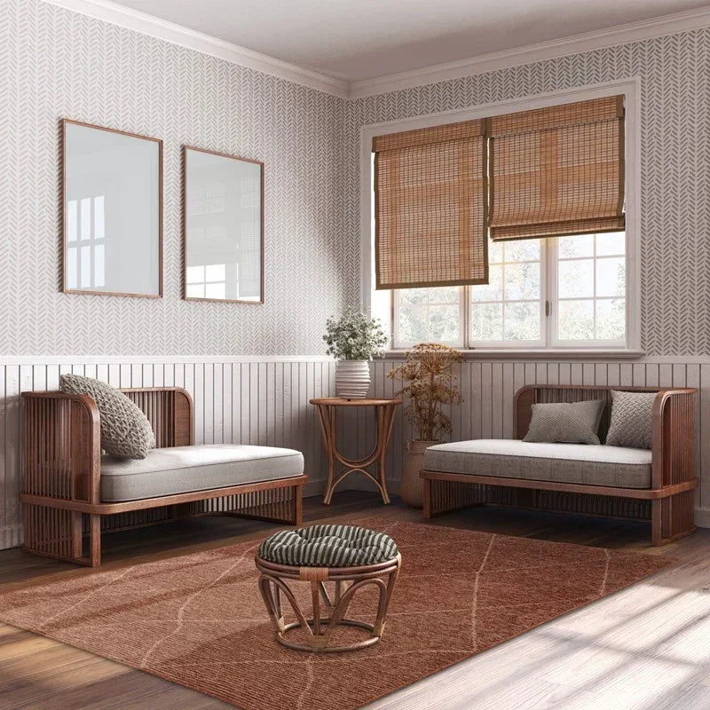 Rattan lounge set with beige cushions, round ottoman and side table in bright living room