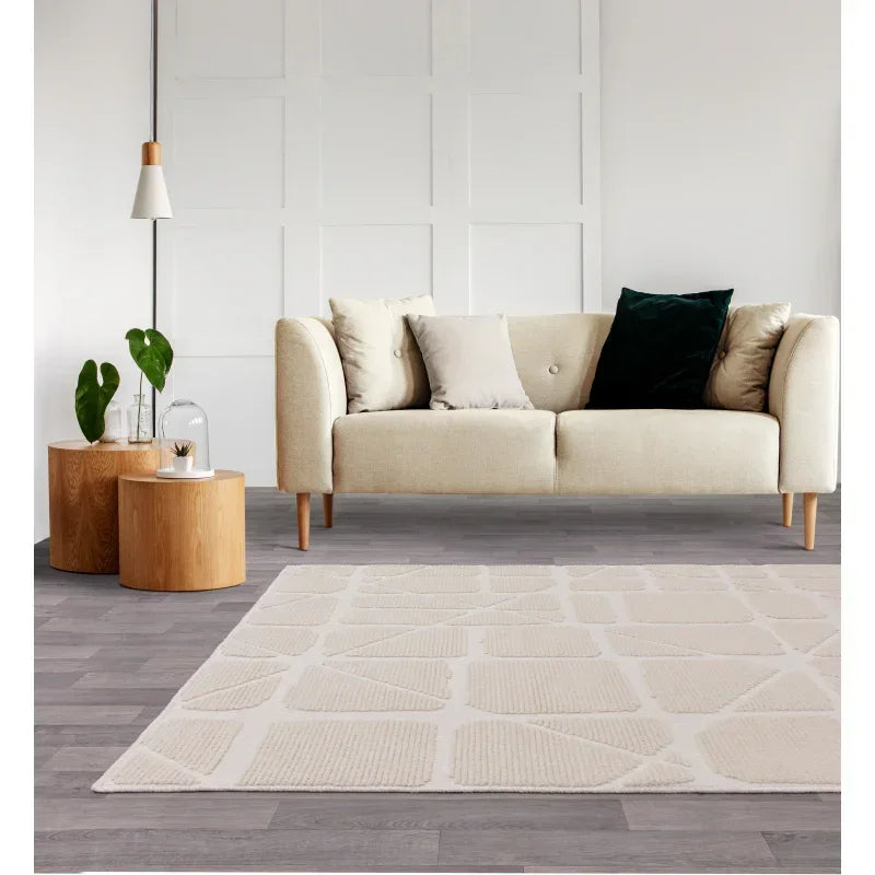 Beige fabric sofa with mixed scatter cushions, wooden side tables and modern geometric rug