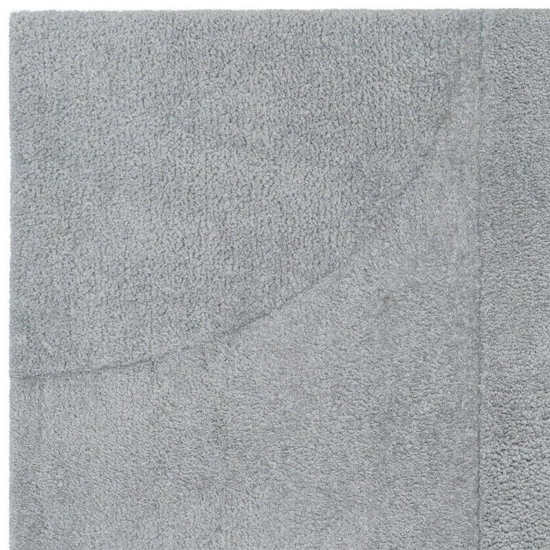 Closeup of a grey textured bath mat with subtle geometric pattern detail