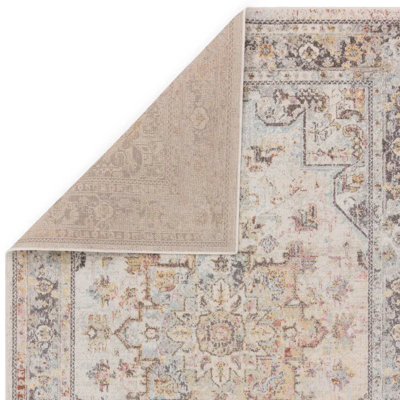 Corner detail of vintage style area rug with muted floral pattern and soft woven texture