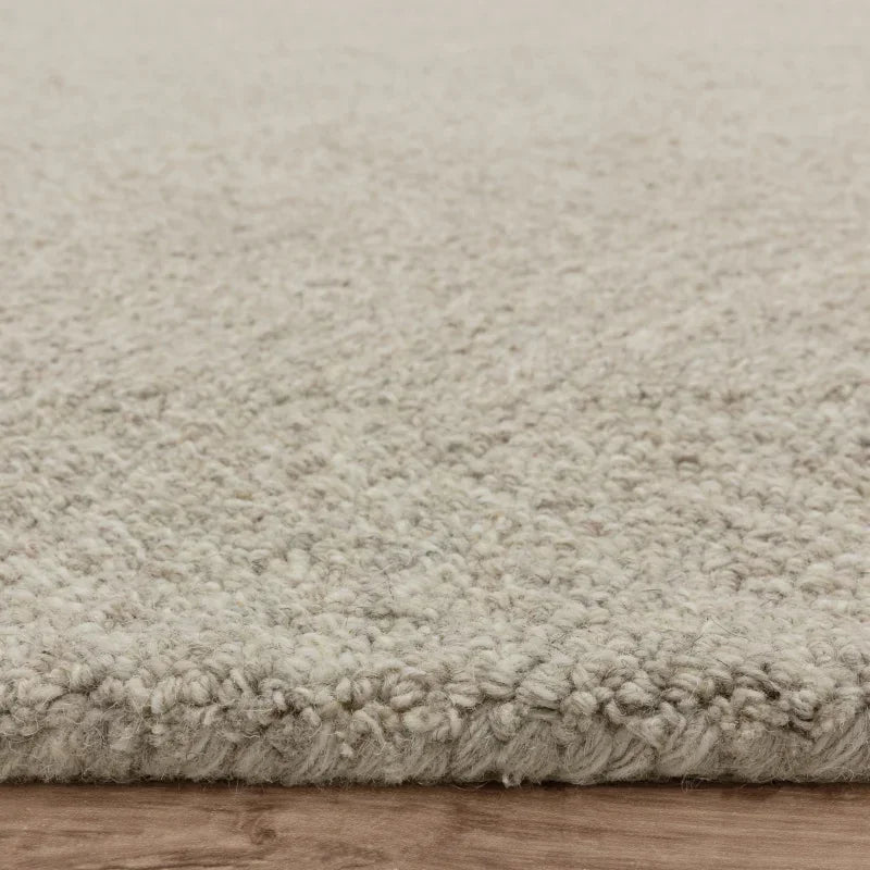 Close-up of beige textured wool rug on wooden floor