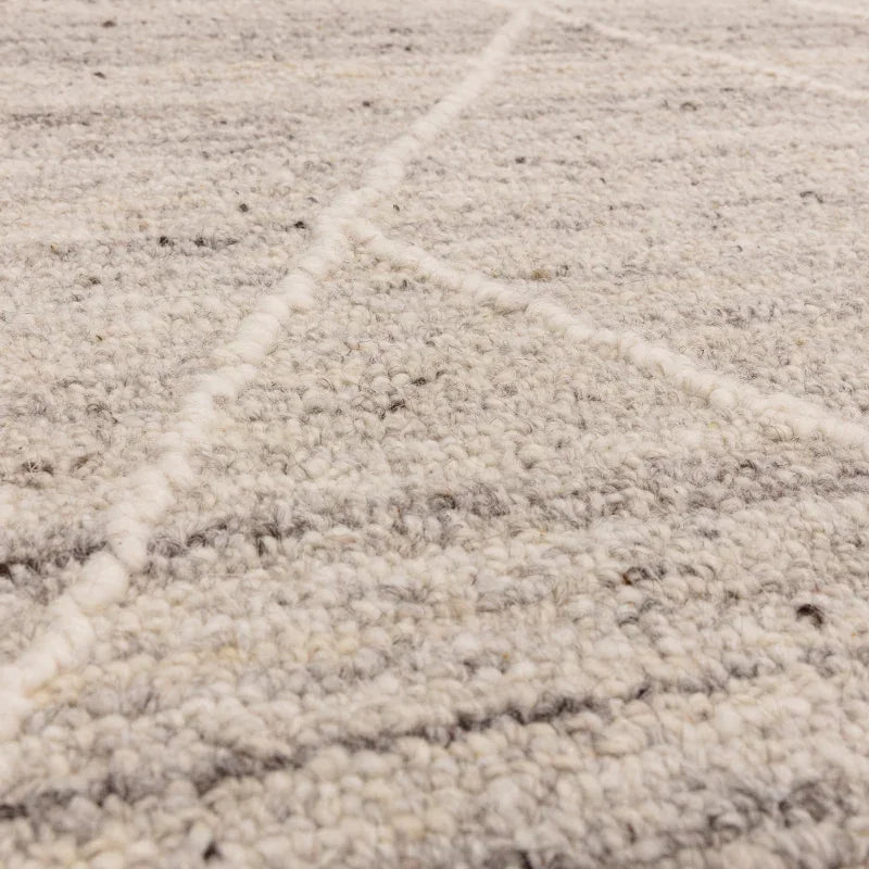 Closeup of textured wool rug with subtle grey and cream lines pattern