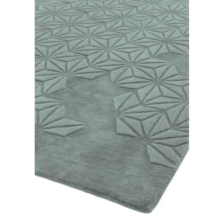 Grey geometric patterned rug with embossed diamond shapes, corner angle view