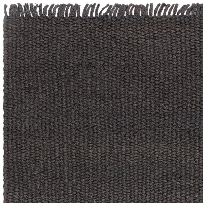Dark wool textured rug closeup with fringe edge detail