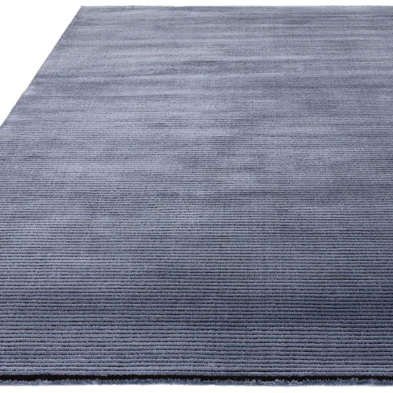 Grey textured rug with subtle horizontal lines viewed from a low angle