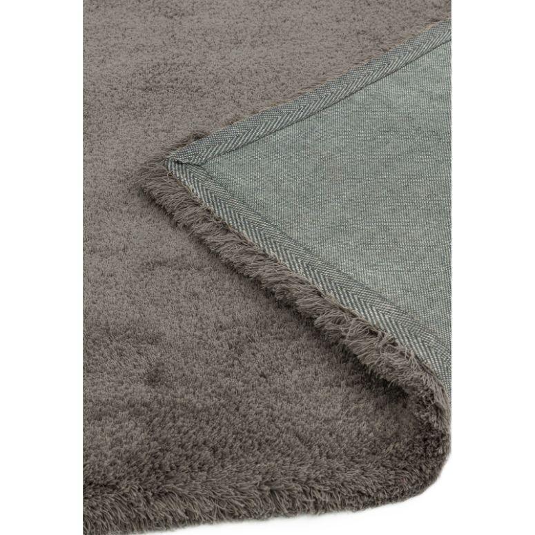Close up of grey shaggy rug with herringbone fabric backing and fringed edge