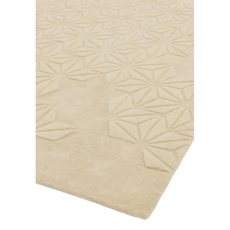 Beige area rug with geometric embossed pattern and soft textured surface