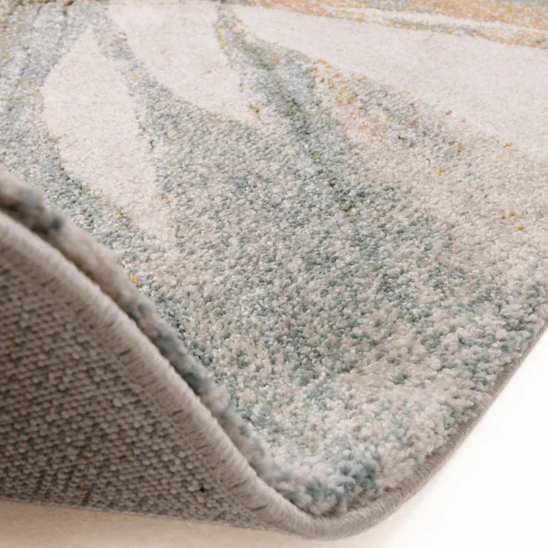 Close-up of textured area rug with abstract pattern in blue and beige tones