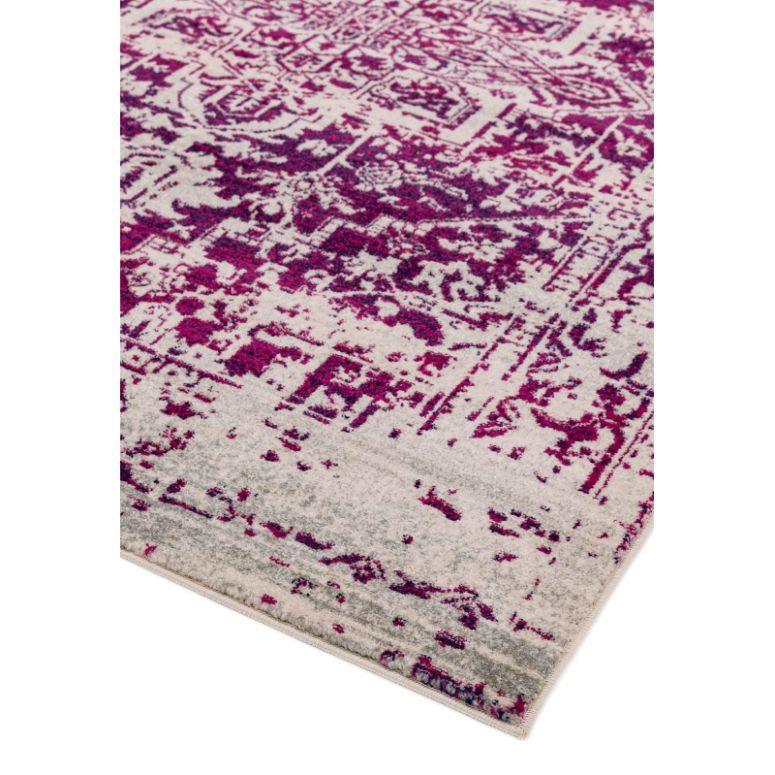 Corner view of purple patterned rug with distressed design on a cream background