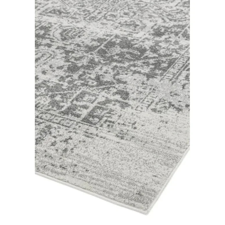 Grey and white patterned area rug corner with distressed vintage design