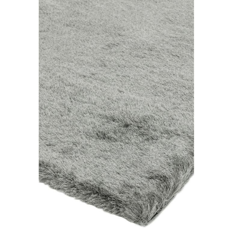 Closeup of light grey shaggy rug corner showing soft textured pile