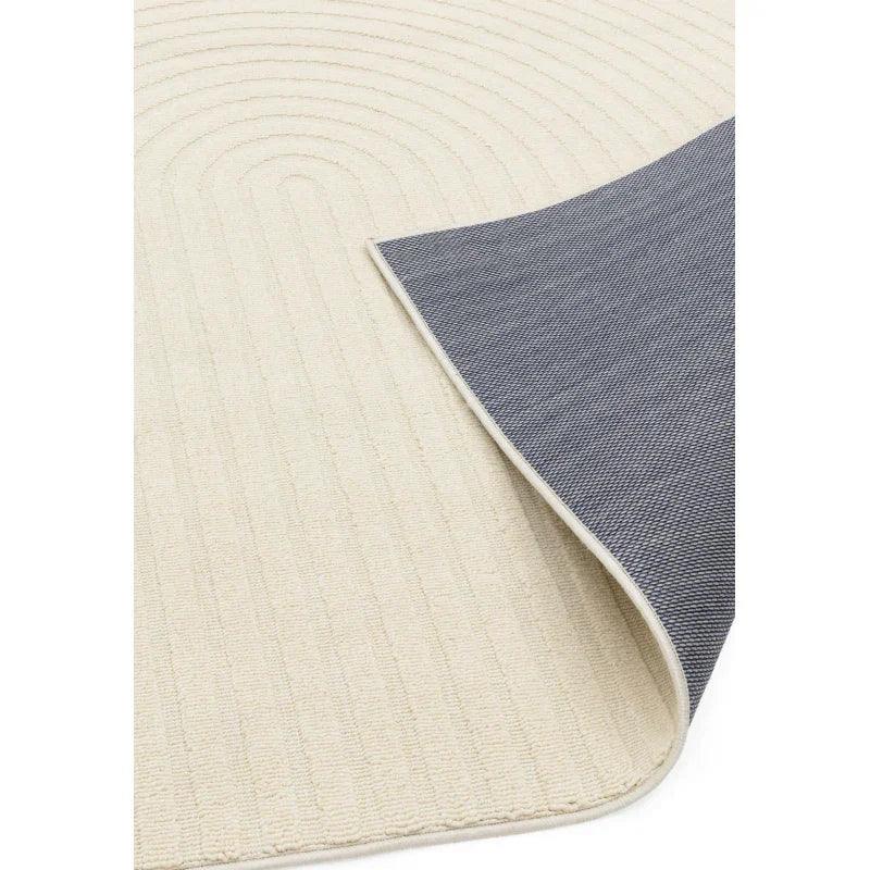 Cream textured rug with curved pattern, corner flipped showing dark grey backing