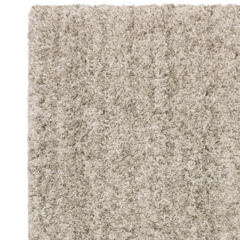 Close-up of beige shaggy rug texture showing thick pile and soft fibres