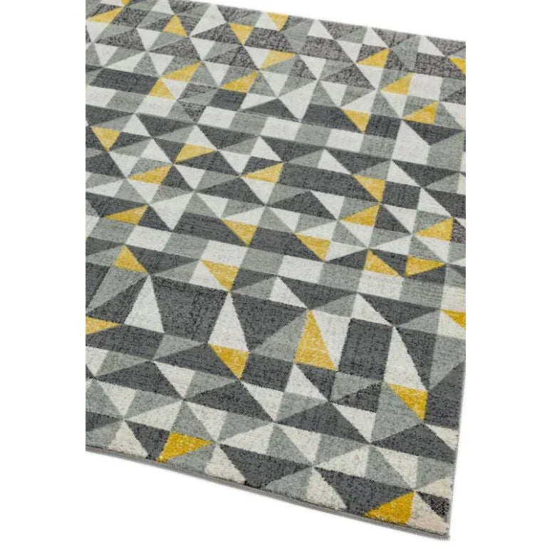 Geometric patterned rug with grey, white, and yellow triangles on angled view