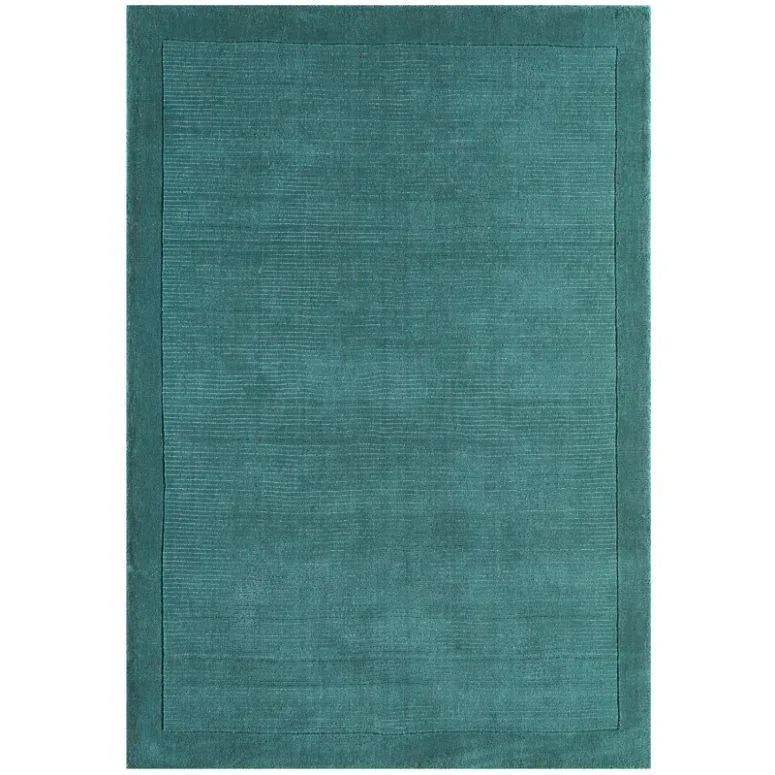 Teal area rug with subtle textured border and solid color design